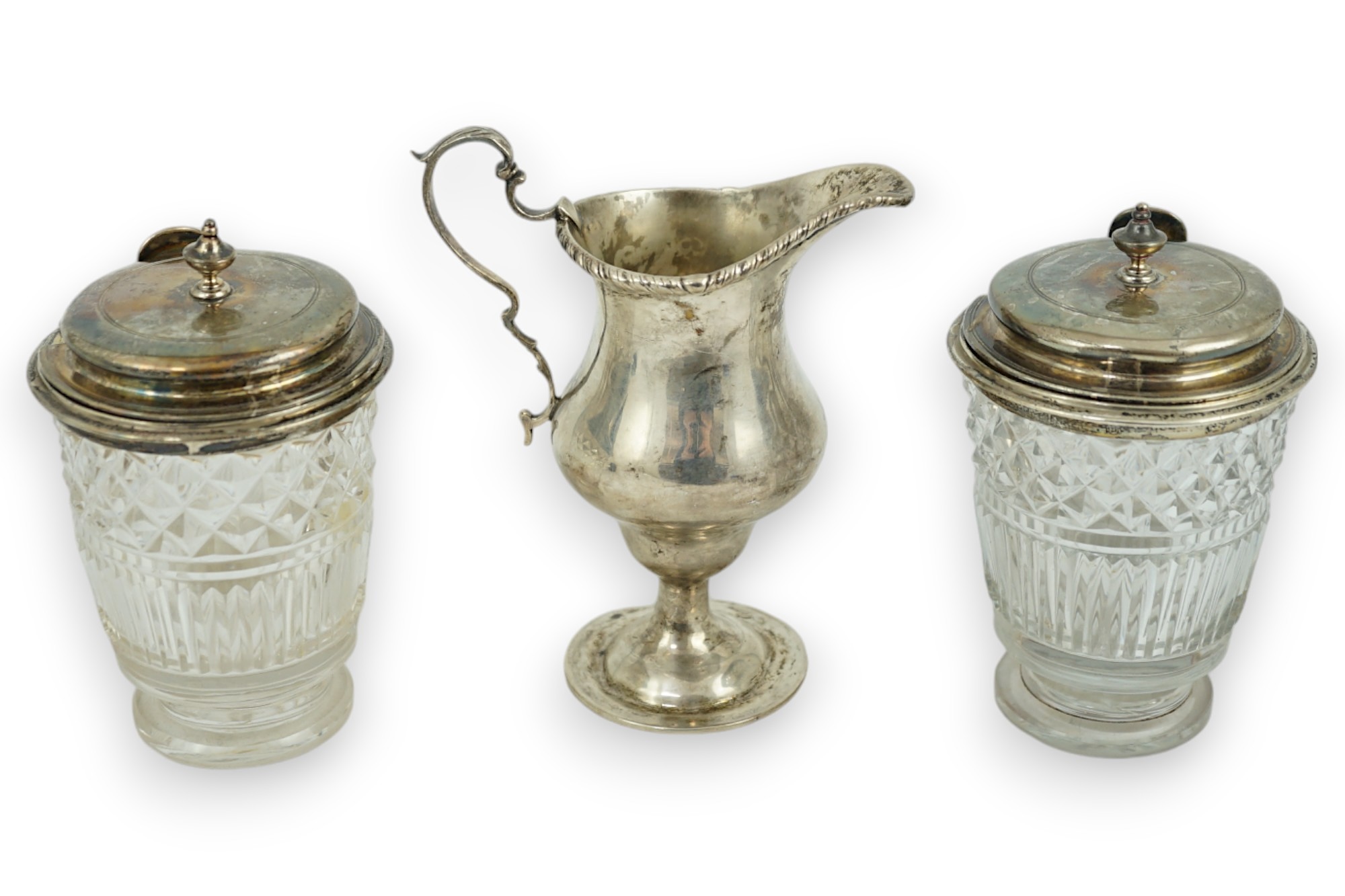 Two George III silver mounted glass cruet bottles, London, 1808, height 12.6cm and a late Victorian silver inverted pear shaped cream jug.